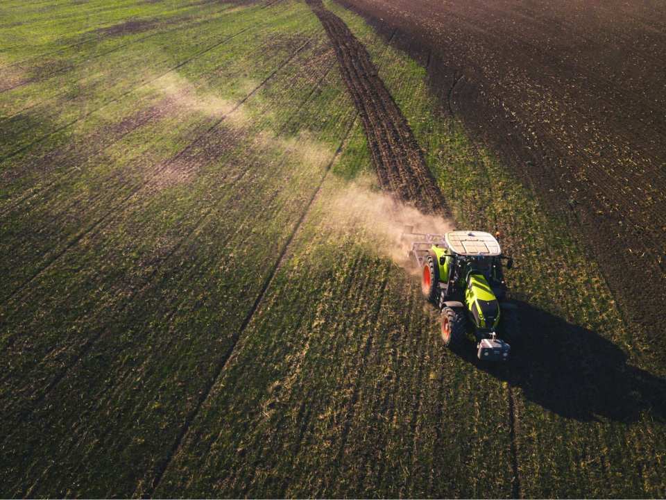Tractor verde y blanco en un campo de hierba verde durante el día